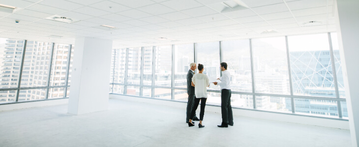 image of three people looking at a potential commercial space for lease